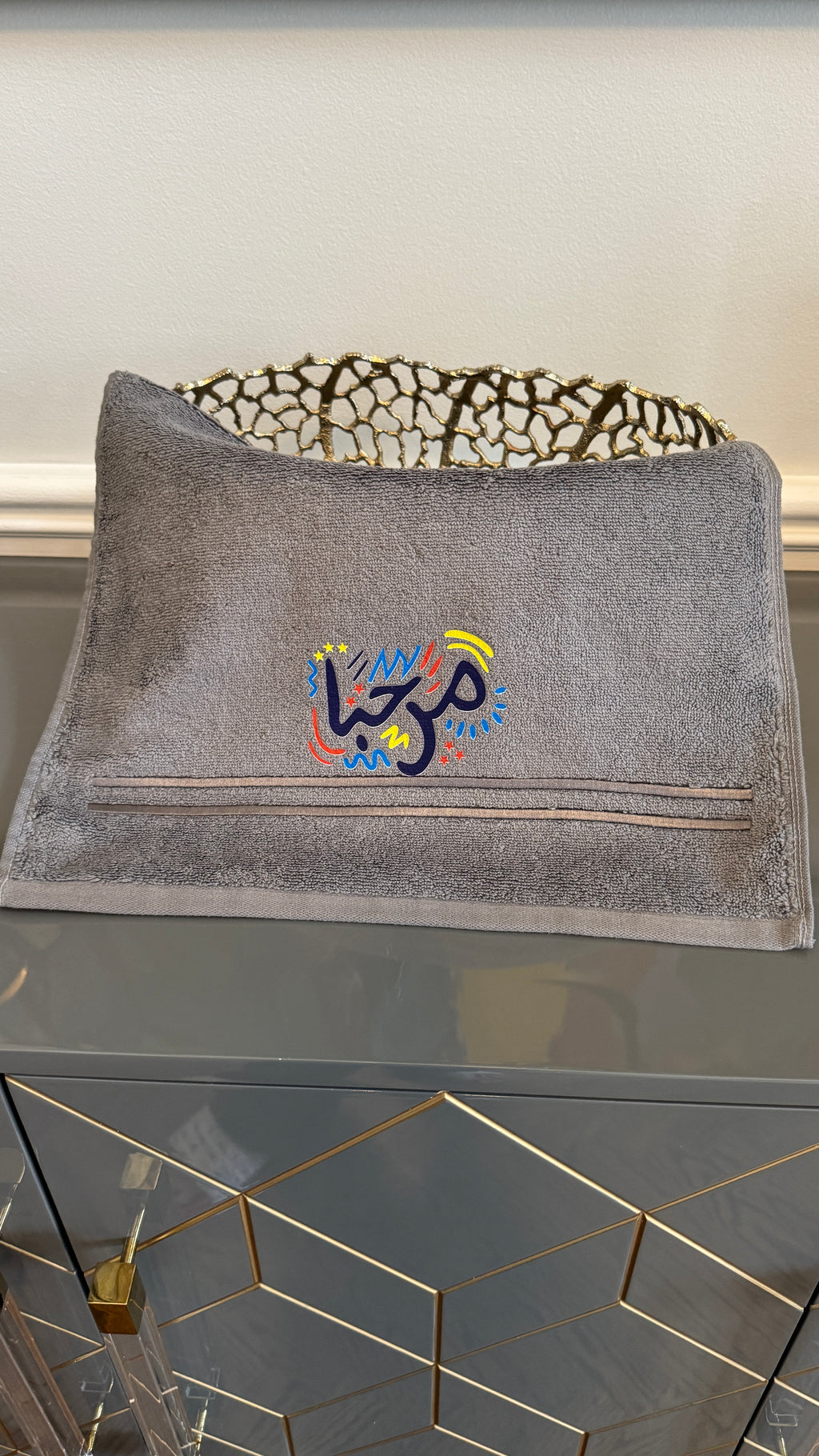 Gray towel designed with artistic Arabic Calligraphy مرحبا “marhaba”