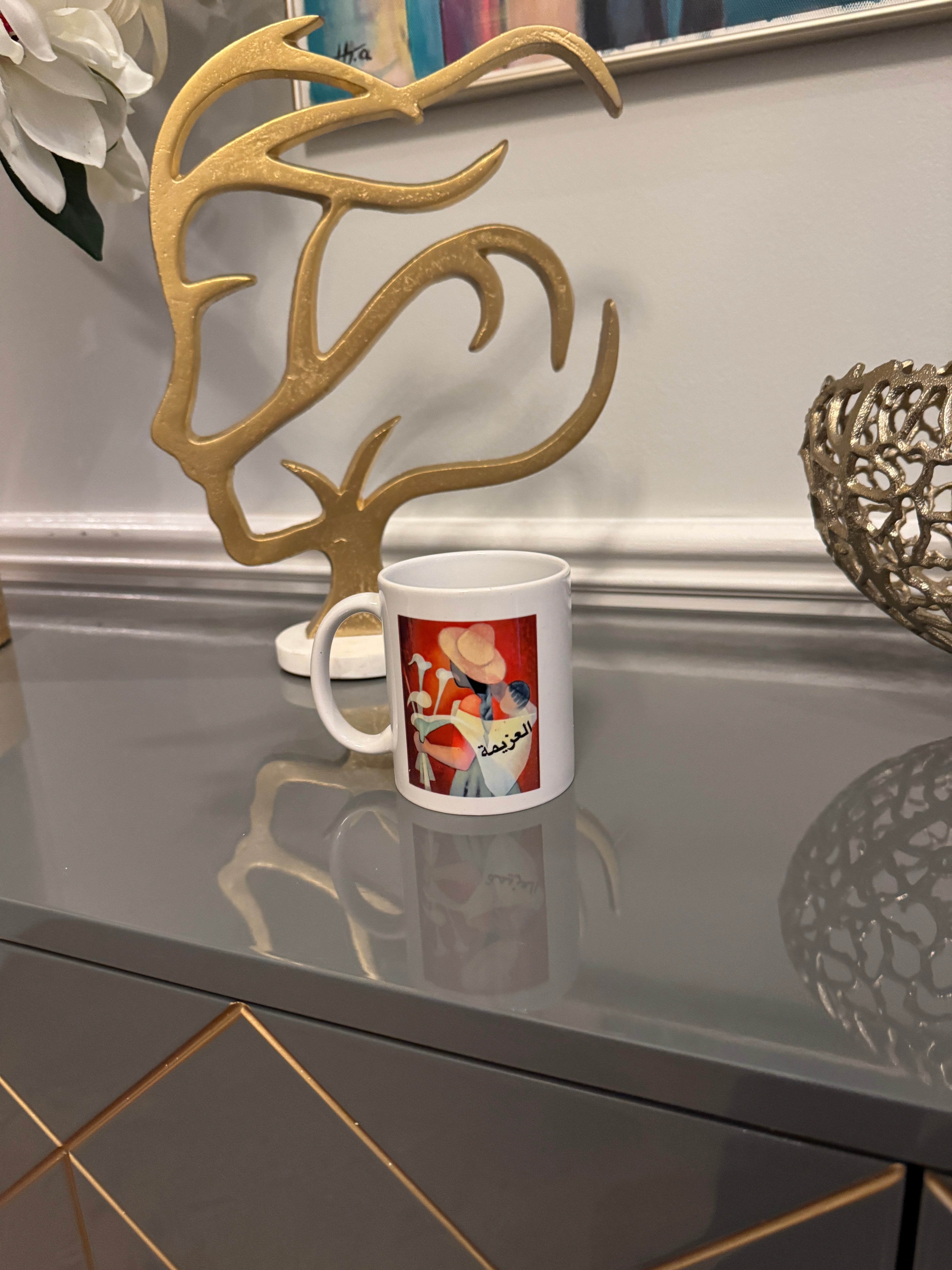 White mug designed with a powerful women image and Arabic Caligraphy العزيمة