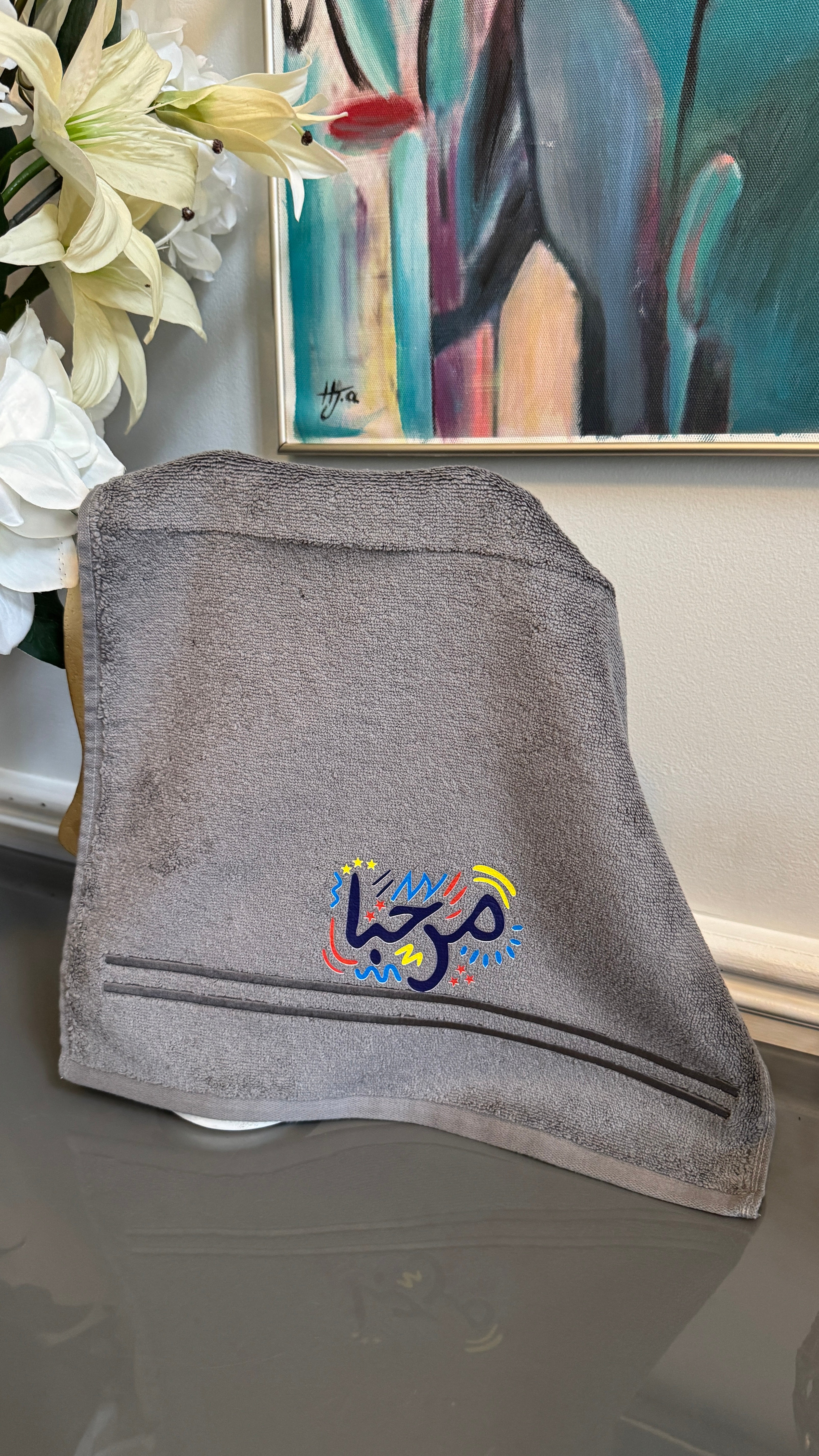 Gray towel designed with artistic Arabic Calligraphy مرحبا “marhaba”