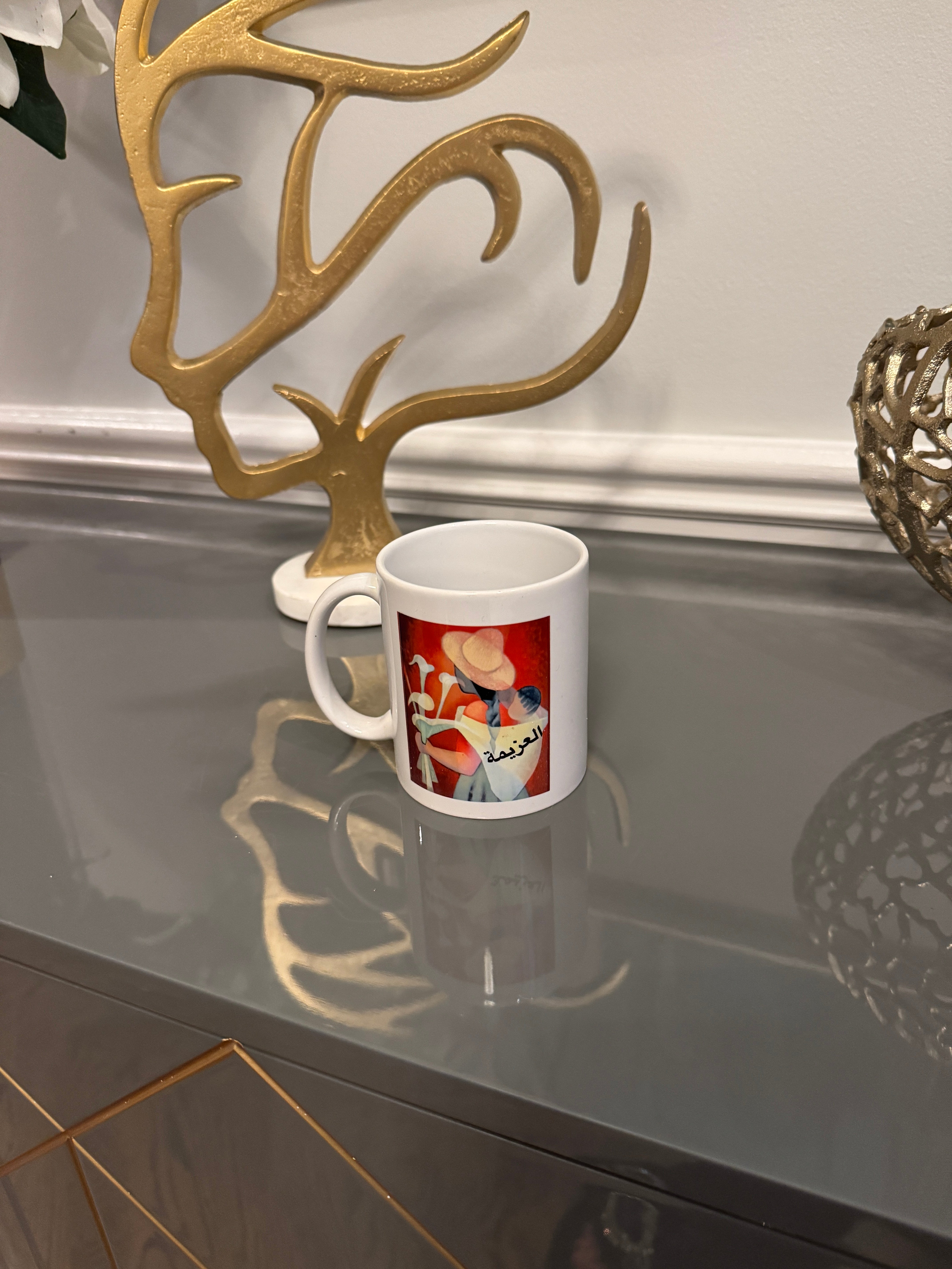 White mug designed with a powerful women image and Arabic Caligraphy العزيمة