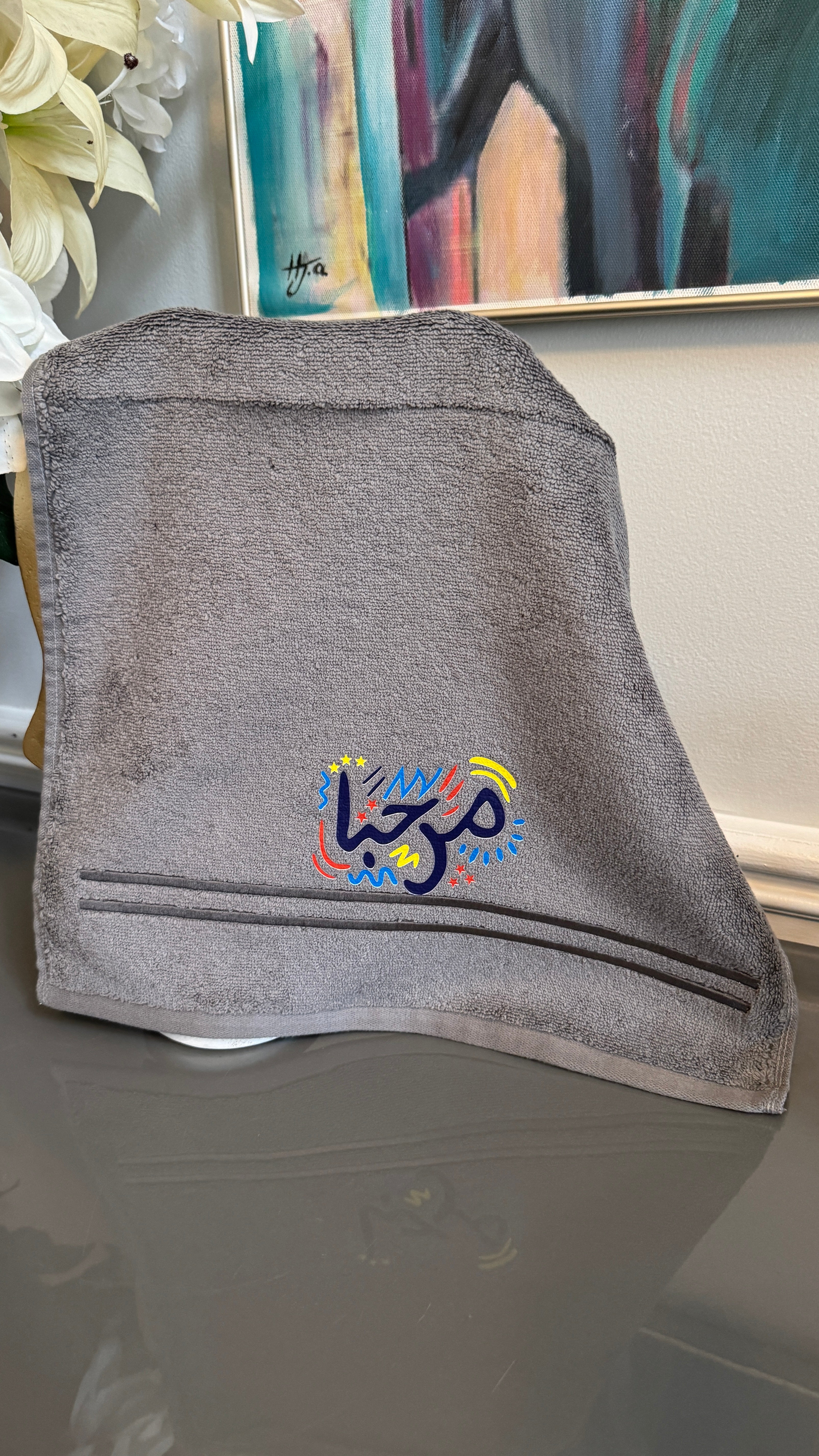 Gray towel designed with artistic Arabic Calligraphy مرحبا “marhaba”